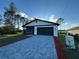 Charming home featuring a modern white and black color scheme, brick driveway, and manicured lawn at 1102 East Pkwy, Deland, FL 32724