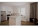 Bright kitchen features white cabinets, a stainless steel refrigerator, and a large center island at 1102 East Pkwy, Deland, FL 32724