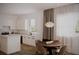 Well-lit kitchen with white cabinets, a dining area, and a modern light fixture at 1102 East Pkwy, Deland, FL 32724