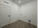 Bright laundry room featuring sleek flooring, white door, and utility connections at 1102 East Pkwy, Deland, FL 32724