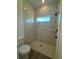 Elegant walk-in shower with marble-patterned tile walls, a shower head, and a small window at 1102 East Pkwy, Deland, FL 32724