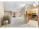 Bright, carpeted living room with vaulted ceilings adjacent to a kitchen with wooden cabinets at 3383 Westchester Square Blvd # 204, Orlando, FL 32835