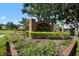 Community sign featuring 'The Hamptons' at Metro West surrounded by lush landscaping and a well-maintained lawn with gazebo at 3383 Westchester Square Blvd # 204, Orlando, FL 32835