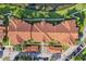 Overhead view of a red-tiled apartment roof surrounded by landscaping and parking areas at 5530 Metrowest Blvd # 9-211, Orlando, FL 32811