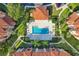 Top-down look at community pool with lounge area, surrounded by lush foliage and walkways at 5530 Metrowest Blvd # 9-211, Orlando, FL 32811