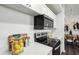 Modern kitchen features white cabinets, a black microwave, an oven, and white quartz countertops at 5530 Metrowest Blvd # 9-211, Orlando, FL 32811