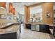 This open concept kitchen features granite countertops, stainless appliances, dark wood cabinets, and recessed lighting at 5530 Metrowest Blvd # 9-211, Orlando, FL 32811
