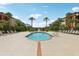 A tranquil community pool surrounded by lounging space, palm trees and manicured grounds at 5530 Metrowest Blvd # 9-211, Orlando, FL 32811