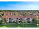 Attractive aerial view of an apartment community, showcasing manicured lawns, mature trees, and Mediterranean-style architecture at 5530 Metrowest Blvd # 9-311, Orlando, FL 32811