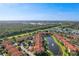Overhead shot presenting a tranquil community pond with mediterranean apartments in the distance, showing lush landscaping at 5530 Metrowest Blvd # 9-311, Orlando, FL 32811
