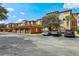 Apartment building with garages in a parking lot with mature trees at 5530 Metrowest Blvd # 9-311, Orlando, FL 32811
