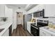 Updated kitchen featuring stainless steel appliances, ample counter space, and modern white cabinets for style and functionality at 5530 Metrowest Blvd # 9-311, Orlando, FL 32811