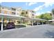 Condo complex parking area with carports, landscaping, and available parking spaces at 6451 Old Park Ln # 110, Orlando, FL 32835