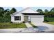 Charming single-story home with a two-car garage, manicured lawn, and neutral color palette at 6646 Rhythm Dr, Mascotte, FL 34753