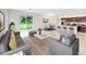 Open-concept living room with modern furniture, dining area, and seamless flow into the kitchen at 6646 Rhythm Dr, Mascotte, FL 34753