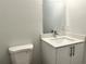 This bathroom features a toilet, white vanity, quartz countertop and a mirror at 1310 Tallahassee Ct, Poinciana, FL 34759