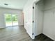 Bright bedroom featuring wood flooring, a closet, and a sliding glass door leading to the outside at 1310 Tallahassee Ct, Poinciana, FL 34759