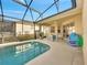 Screened-in pool area with patio furniture and grill at 511 Pineloch Dr, Haines City, FL 33844