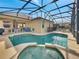 Inviting screened pool and spa with patio furniture, creating an outdoor oasis at 511 Pineloch Dr, Haines City, FL 33844
