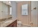Powder room features granite vanity and decorative striped wallpaper at 7642 Fairgrove Ave, Windermere, FL 34786
