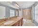 Bathroom with dual vanities, granite counters, and tiled glass shower at 7642 Fairgrove Ave, Windermere, FL 34786