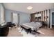 Stylish bedroom with an elegant upholstered bed, decorative lighting and a striped accent wall at 7642 Fairgrove Ave, Windermere, FL 34786