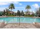 Inviting community pool with lounge chairs, umbrellas, and lush landscaping at 7642 Fairgrove Ave, Windermere, FL 34786