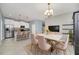 Open dining area featuring a modern light fixture, large kitchen island with breakfast bar, and neutral color palette at 7642 Fairgrove Ave, Windermere, FL 34786