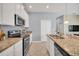 Bright kitchen with stainless steel appliances, granite countertops, and white cabinets at 7642 Fairgrove Ave, Windermere, FL 34786