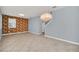 Bright, open-concept living area with unique feature wall, tile flooring, and modern chandelier lighting at 7642 Fairgrove Ave, Windermere, FL 34786