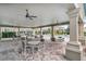 Covered seating area with tables and chairs near the pool, perfect for relaxing and socializing at 7642 Fairgrove Ave, Windermere, FL 34786