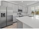 Modern kitchen with stainless steel appliances, gray cabinets, island with a white countertop at 1197 Happy Forest Loop, Deland, FL 32720