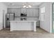 Modern kitchen features stainless steel appliances, gray cabinets, and an island with white countertop at 1197 Happy Forest Loop, Deland, FL 32720