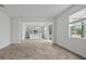 Large, empty living room shows tile floors, a large window and view into the kitchen at 1197 Happy Forest Loop, Deland, FL 32720