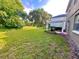 Expansive backyard featuring lush green grass, mature trees, and a charming pergola-covered patio at 122 Stone Gable Cir, Winter Springs, FL 32708