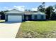 Beautiful home with a well-manicured lawn, long driveway, and an attached garage at 1209 Alafia Way, Poinciana, FL 34759