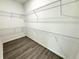 Walk-in closet features custom shelving and wood-style flooring at 1209 Alafia Way, Poinciana, FL 34759