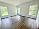 Sunlit bedroom featuring sleek hardwood floors and three large windows at 1312 Hillsborough Ct, Poinciana, FL 34759