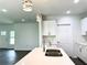 Modern kitchen featuring a stainless steel sink, white cabinetry, and stylish pendant lighting at 1312 Hillsborough Ct, Poinciana, FL 34759