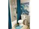 Bright bathroom featuring a bathtub with shower, blue rug, and a vivid wave painting at 1990 Erving Cir # 201, Ocoee, FL 34761