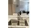 Stainless steel double kitchen sink with granite counter and view into living space at 1990 Erving Cir # 201, Ocoee, FL 34761