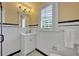 Bright bathroom with white subway tile, striking black accents, and plantation shutters at 727 Park Lake Cir, Orlando, FL 32803