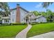 Charming two-story home featuring a brick chimney, manicured landscaping, and a welcoming walkway at 727 Park Lake Cir, Orlando, FL 32803