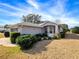 Ranch-style home with gray siding and well-maintained landscaping at 20505 Queen Alexandra Dr, Leesburg, FL 34748