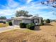 Gray house with a screened porch and attached garage at 20505 Queen Alexandra Dr, Leesburg, FL 34748