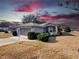 Cute one-story home with gray siding, screened-in garage, and a well-maintained lawn at 20505 Queen Alexandra Dr, Leesburg, FL 34748