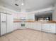 Bright kitchen with white cabinetry, ample counter space, and a view into another room at 20505 Queen Alexandra Dr, Leesburg, FL 34748