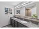 Elegant bathroom with double vanity, granite countertop, decorative lighting and tiled floors at 13427 Blue Heron Beach Dr # 405, Orlando, FL 32821
