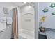 Bright bathroom featuring a shower-tub combo with granite counters and floral decorations at 13427 Blue Heron Beach Dr # 405, Orlando, FL 32821