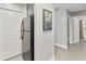 Hallway featuring tiled floors and leading to the bathroom and a stainless steel refrigerator at 13427 Blue Heron Beach Dr # 405, Orlando, FL 32821